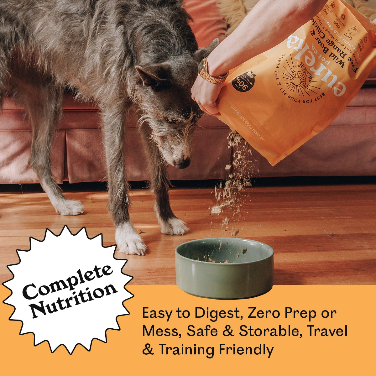 Eureka Pet Co. Wild Boar & Free Range Chicken air-dried dog food being poured into a ceramic bowl for a large grey dog — complete nutrition that is easy to digest, zero prep, safe, storable and travel and training friendly.