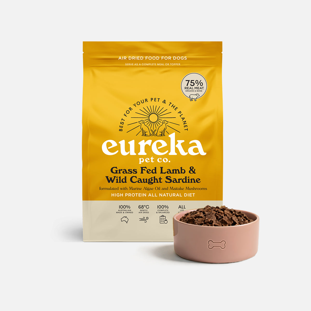 Bag of Eureka Pet Co Grass Fed Lamb & Wild Caught Sardine air-dried dog food beside a pink bowl filled with the food