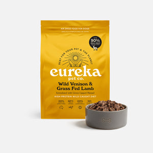 Bag of Eureka Pet Co Wild Venison & Grass Fed Lamb air-dried dog food beside a grey bowl filled with the food.