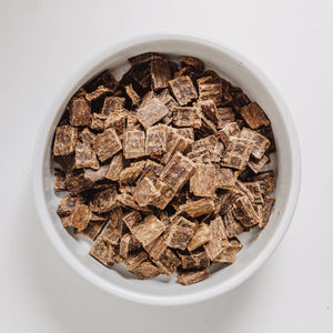Eureka nutrient-dense brown air-dried dog food in a white ceramic dog bowl.