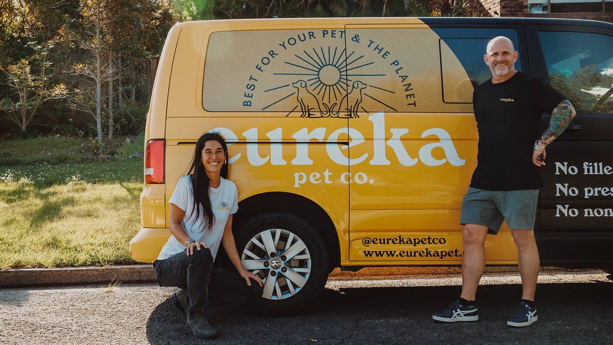 Eureka Pet Co yellow and black van with co-founders posed and smiling in front of it.